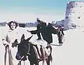 A tourist visits Qatif Castle as a local strikes a playful pose, 1953