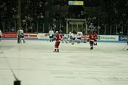 In-game action photo of late middle-aged men playing ice hockey
