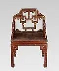 Red lacquer armchair with painted gold and black motifs, Qing dynasty, 18th–19th century.