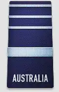 A black shoulder board with the word "AUSTRALIA" across the bottom. Above the word is a thick, blue horizontal stripe, with three thinner blue horizontal stripes above that.
