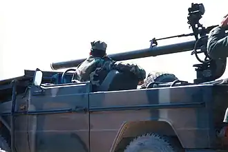 Firing the gun from a Mercedes-Benz 240G.