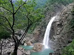 Thin waterfall with spray forming a rainbow