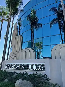 A building with a glass facade and "Raleigh Studios" signage