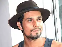 Hooda wearing a hat looking into the camera