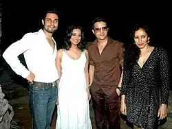 Hooda in a grey suit posing for the camera.