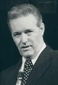 Headshot of Rex Humbard, with a microphone visible at the bottom of the picture.