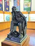 Statue of Cecil Rhodes, surrounded by historical flags of Southern Rhodesia and Rhodesia