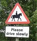 A pictographic traffic sign (top) warning motorists of horses and riders