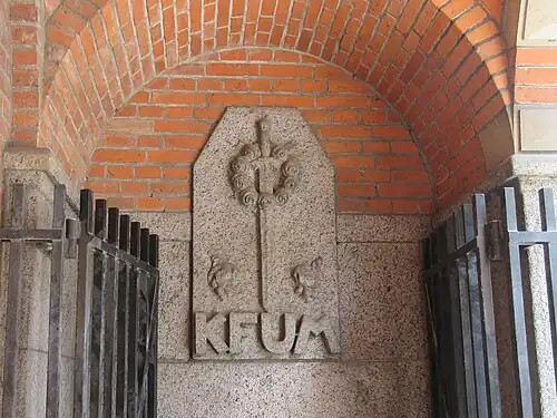 Relief above the basement entrance in the arcade