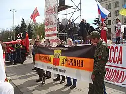 Anti-government far-right Odesskaya Druzhina militants holding a banner on the 20 April, with the neo-Nazi Kolovrat symbol visible on their uniforms
