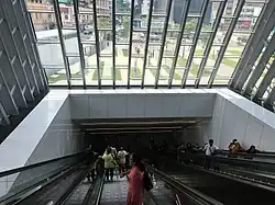 Escalators going down to the MRT station concourse level from the pedestrian link bridge.