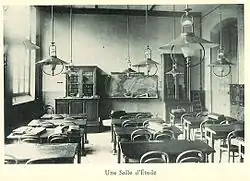 Photograph of a study room at Lycée Molière: tables, chairs, and a blackboard.