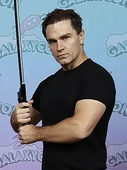 Actor Sam Witwer in 2024 holding a darksaber toy
