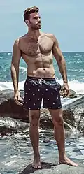 A man wearing swim trunks