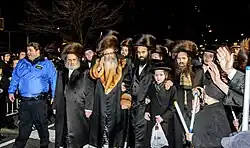 Rabbi Zalman Leib Teitelbaum of Satmar walks surrounded by followers during an escort on the streets of Williamsburg