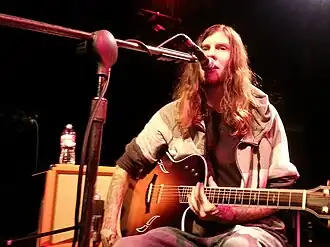 One male guitarist performing on an indoor stage