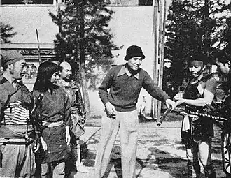 Kurosawa directs an actor playing a bandit while holding a musket