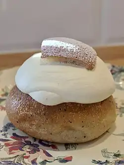 A classic Swedish semla, with a cardamom bun, a small piece of which is cut off and used as a lid.
