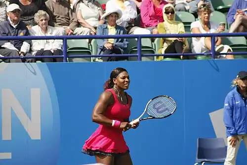 Serena Williams wearing a hot pink ballet skirt while hitting the tennis ball in her match.