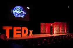 Panchanathan presenting on a large stage with large "T E D X" letters