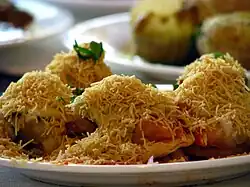 Thin crisps of dough are topped with sev