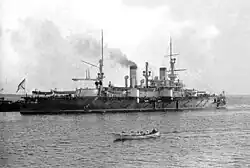A black and white picture of a large ship with a small, lifeboat-sized ship in front of it