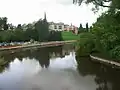 A view from the bridge looking downstream. The Abbey Gardens are on the right.