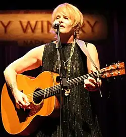 Colvin singing into a microphone