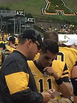 Clark sharing notes with Appalachian State Quarterback Taylor Lamb on the Sidelines of Kidd Brewer Stadium