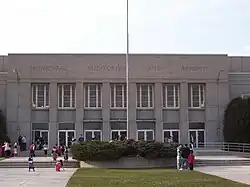 Exterior of the Sheboygan Municipal Auditorium and Armory during the day, with people outside
