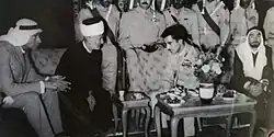 His Highness Prince Muhammad bin Talal of Jordan and Sheikh Mustafa bin Abdul Halim Tahboub al-Marwani, the then Qadi of Amman, sitting in front of him. Sheikh Mustafa Tahboub al-Marwani performed the wedding ceremony of the prince with Princess Firyal