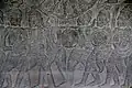 Soldiers carry drums and a shoulder-mounted nipple gong in relief at Angkor Wat.
