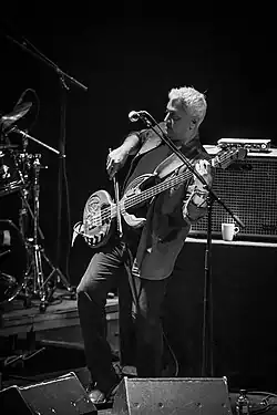 black-and-white picture of Shri Sriram playing a stringed instrument onstage