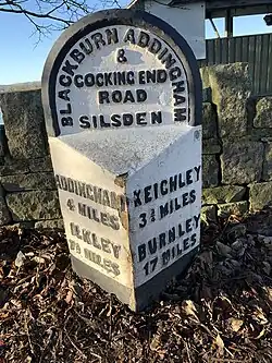 Milestone on A6034 marking boundary of Silsden at River Aire