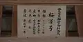 A wooden plaque with Japanese writing listing information about a donated shinme.