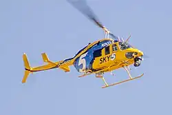 A helicopter in a yellow and blue livery with a large KOCO 5 logo and the text "Sky 5"
