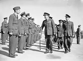 Slessor, with walking stick, before ranks of uniformed personnel