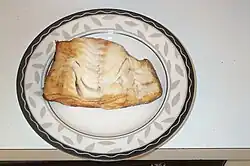 A piece of smoked fish with a browned exterior and whitish interior