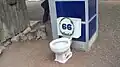 Toilet and phone booth displayed for humorous effect in the garden