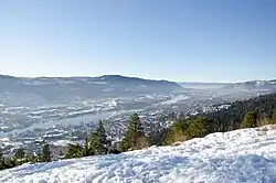 Solbergelva seen from Drammen. The suburb is in the top right corner, below the hills.