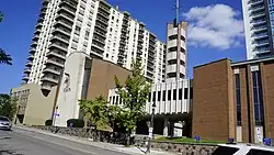 A photo of a church, taken from the street. The church is built in a brutalist style.