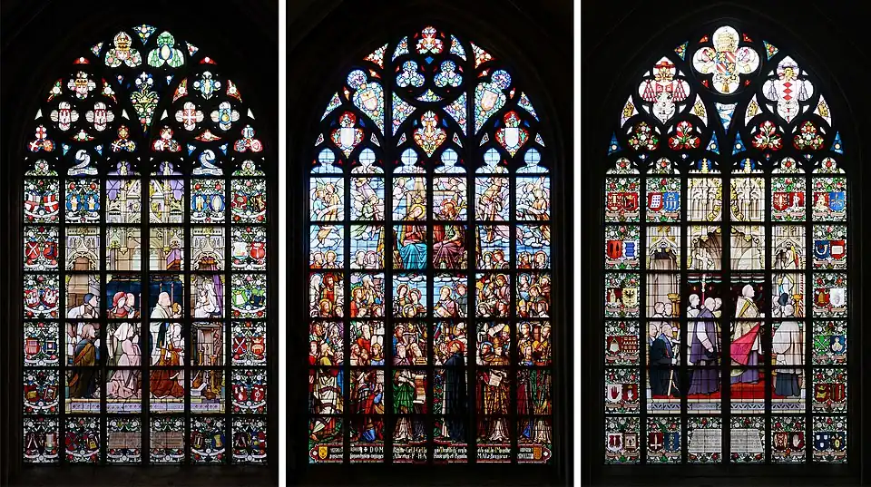 Stained-glass windows. From left to right: Our Lady of Stekske, by Stalins & Janssens, 1878; Saint Ursula and Saint Gaspar, by E. Didron, 1873; and Dedication of the statue of Our Lady of Lourdes by archbishop Deschamps, by Stalins & Janssens, 1885