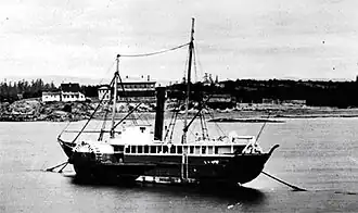 Photograph of the steamship Beaver anchored on a river, showing a side view with masts and paddle structure, circa 1870.
