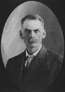 Black and white portrait of a middle age man with a mustache