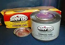 A grey colored can of Sterno on fire