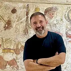 October 2025 photograph of Ivanov with greying beard in a black T-shirt
