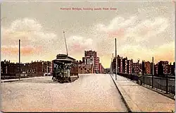 Postcard showing a streetcar on a long bridge in an urban area