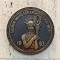 1983 Sir John Sulman Medal affixed to plaza wall.