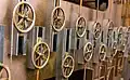 The pulleys move up and down in a sinusoidal motion, representing components of the tide equation. The summation chain that passes above and below the pulleys sums their influences.