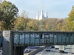 Washington LDS Temple as seen from Interstate 495. The graffiti was updated to say Surrender Donald